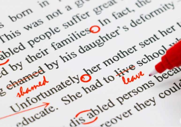 Picture of a person editing a persons book to see if there is any errors. The editor has a red circle on some of the words to make sure the grammar is correct. 